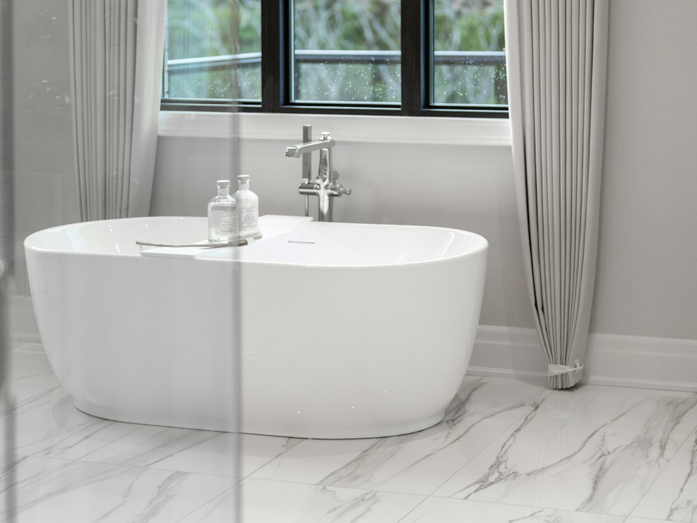 Bathroom with large format light marble look tile floor and a freestanding tub