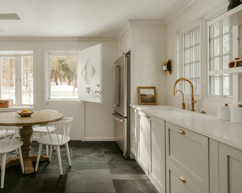 Warm white kitchen with greige shaker cabinets and brushed brass hardware