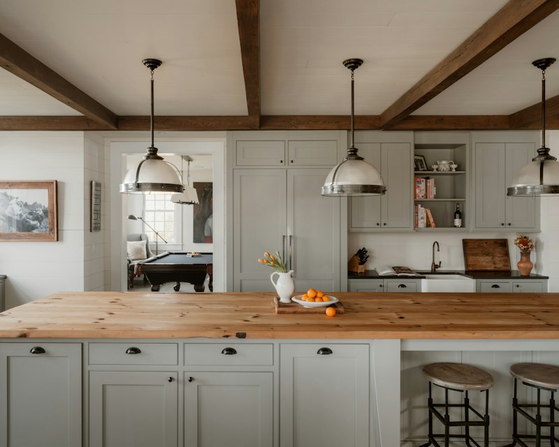 Transitional kitchen with a butcher block island and matte black cup pulls